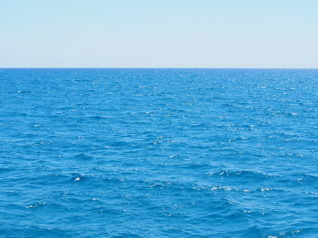 A large body of water with blue sky in the background