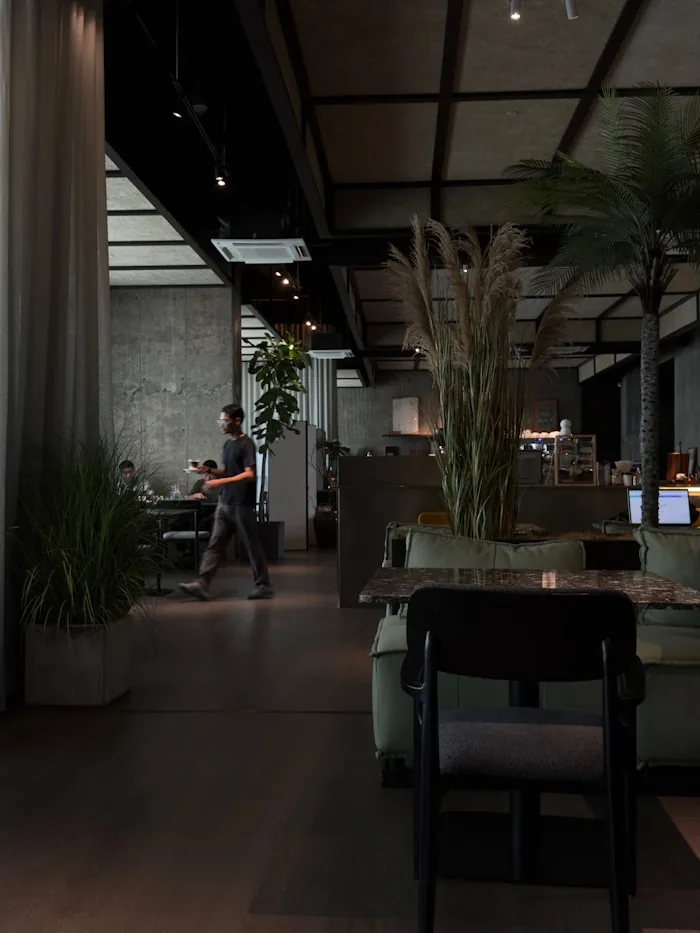 Bitkiler ve oturma alanlarıyla modern kafe içi
