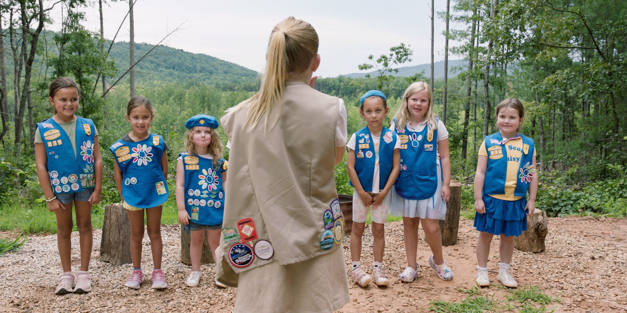 Older Girl Scout stands in facing a line of younger scouts, who listen intently