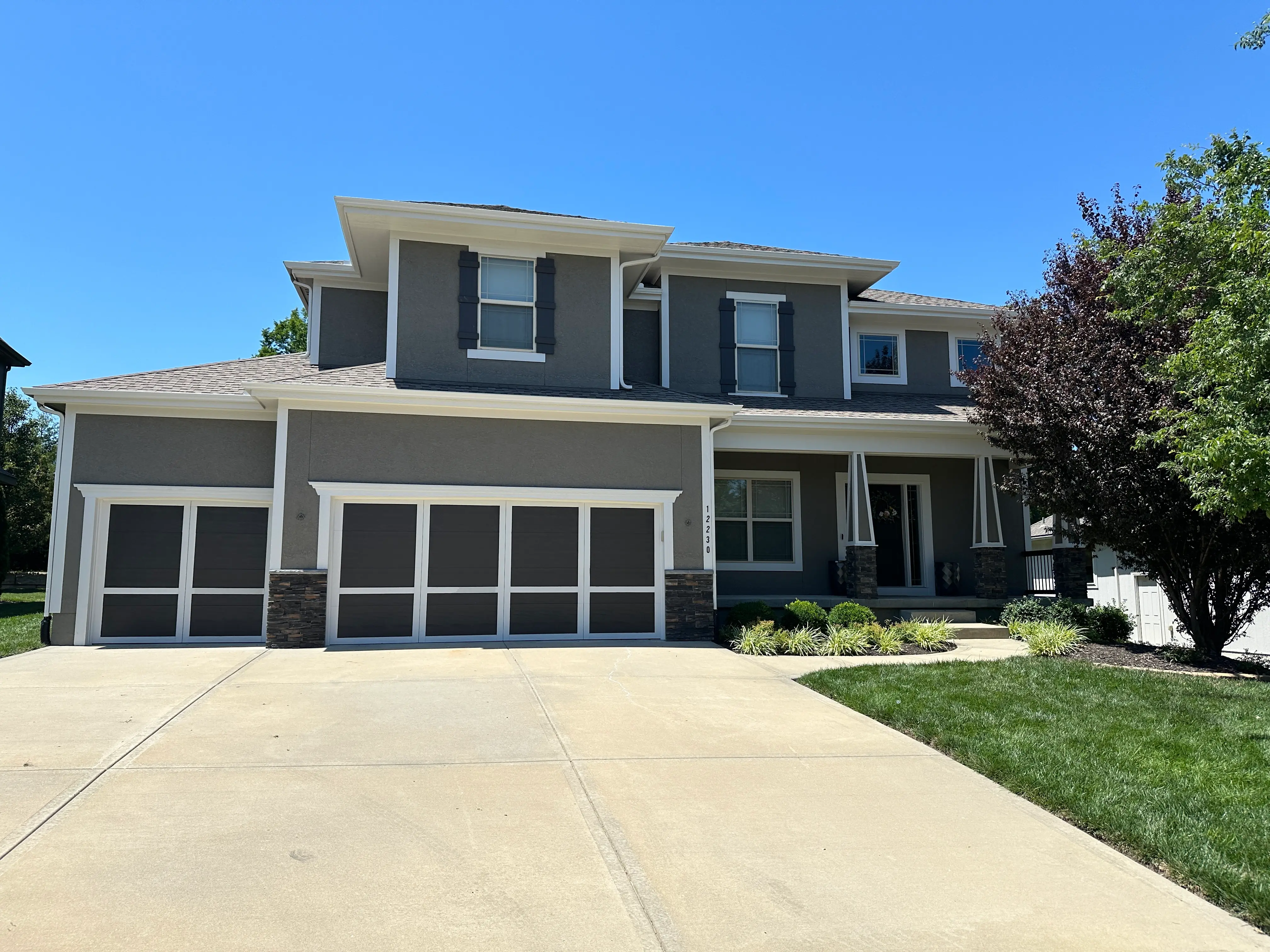 An image of grey house with white trim.