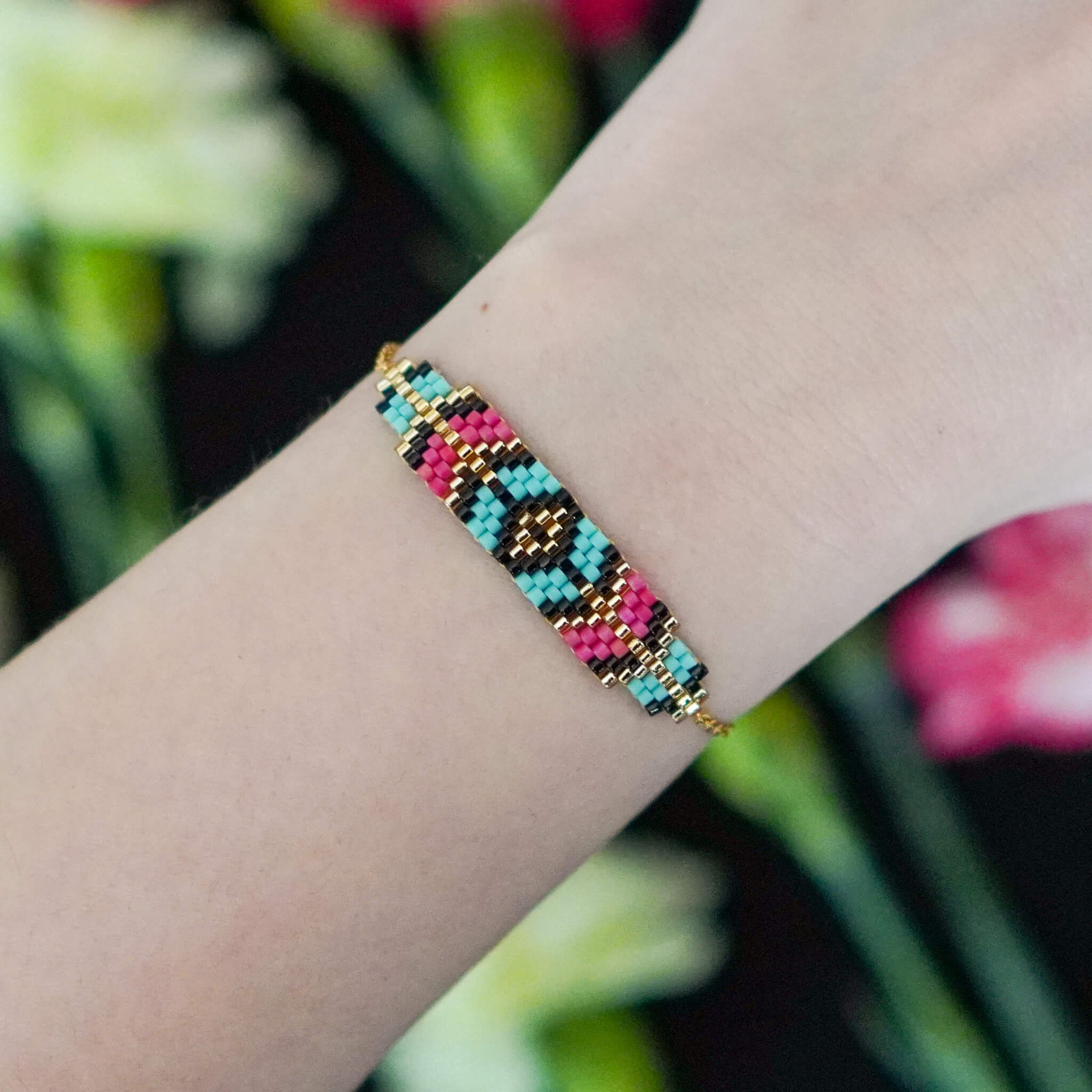 Kolorowa bransoletka Berry Prism na kobiecym nadgarstku, prezentująca kontrastowy, czerwono-niebieski wzór z koralików w dziennym świetle.