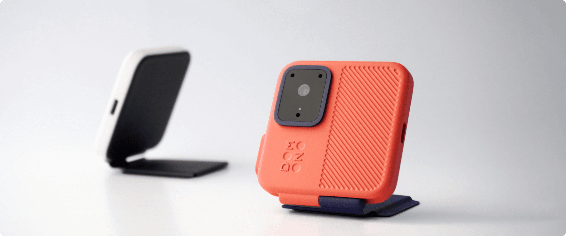 Two different colorways of a portable action camera, showcasing the sleek design in contrasting shades, ideal for attaching to a smartphone case.