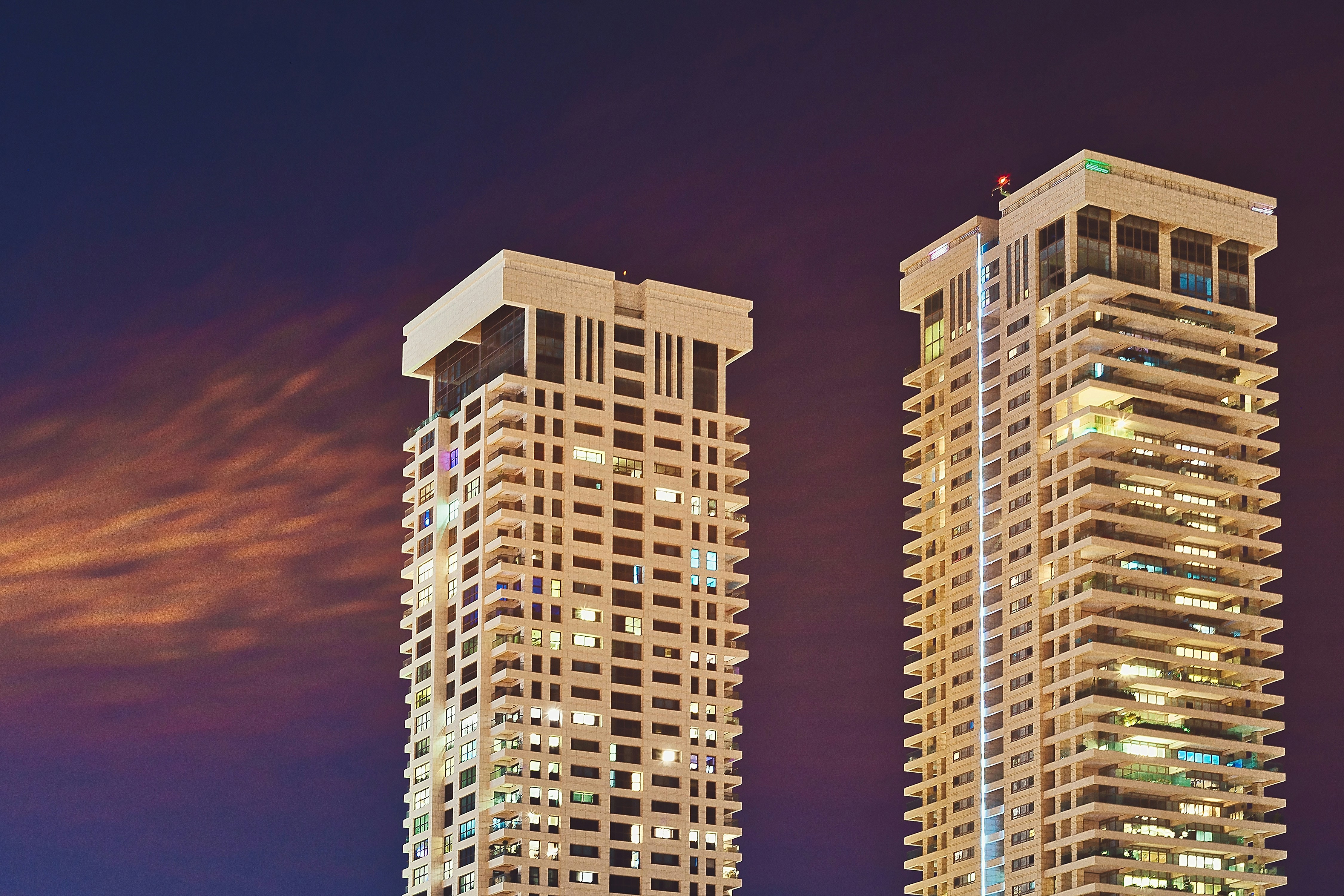 two white high-rise buildings at night time