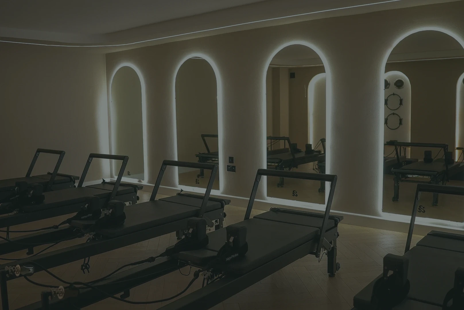 Reformer Pilates studio interior with arched mirrors and LED lighting