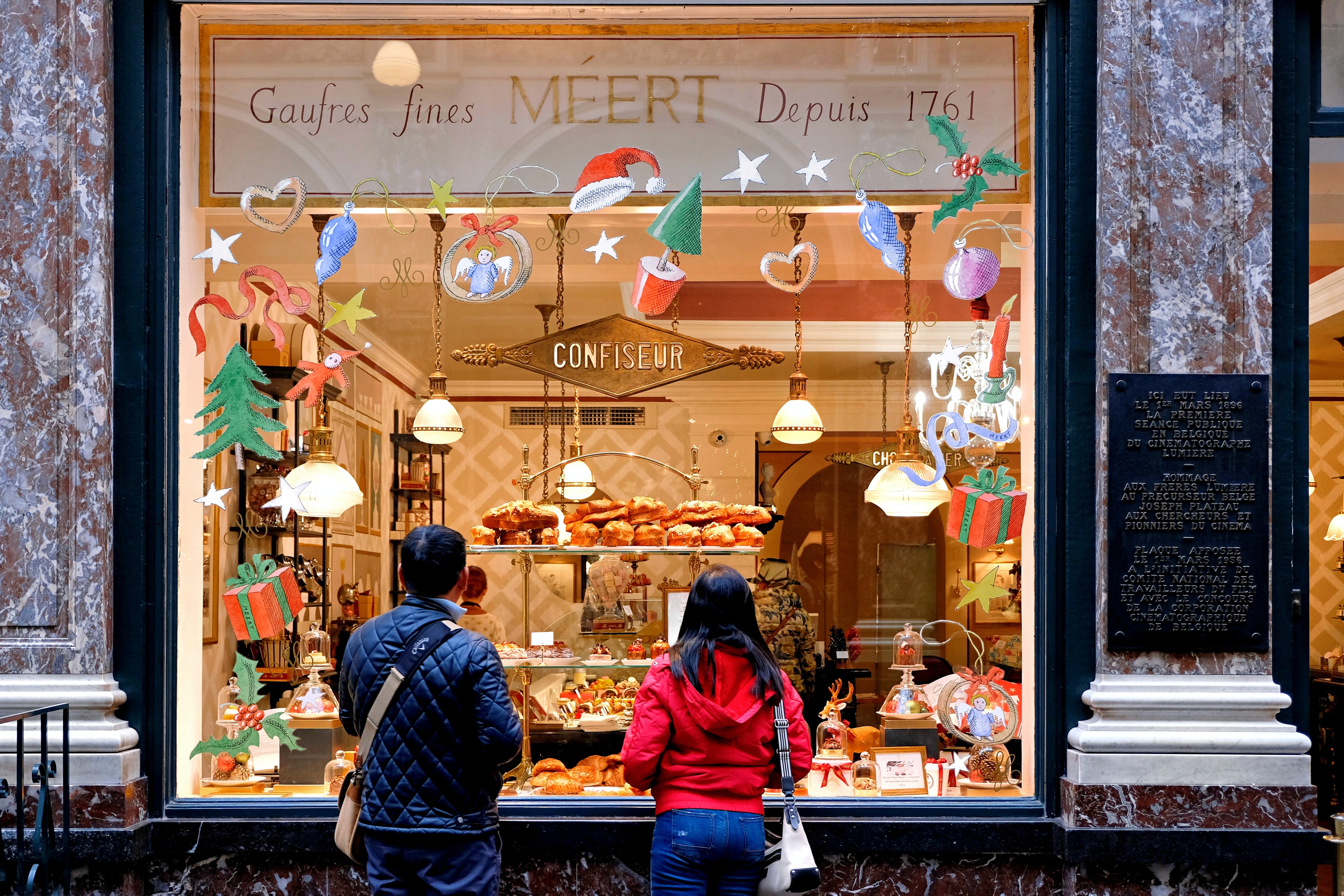 Two people look into a shop window at Christmas time