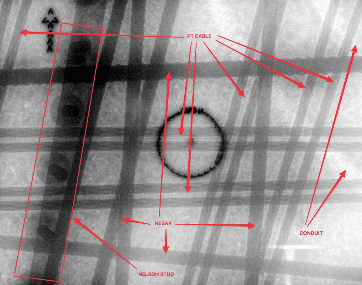 The slab is congested with conduit, PT cables, Nelson studs, and two layers of reinforcing steel. There is no reliable way to identify safe drilling locations for pinning without actual X-ray imaging.