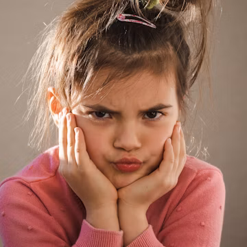 a young girl with her hands on her face