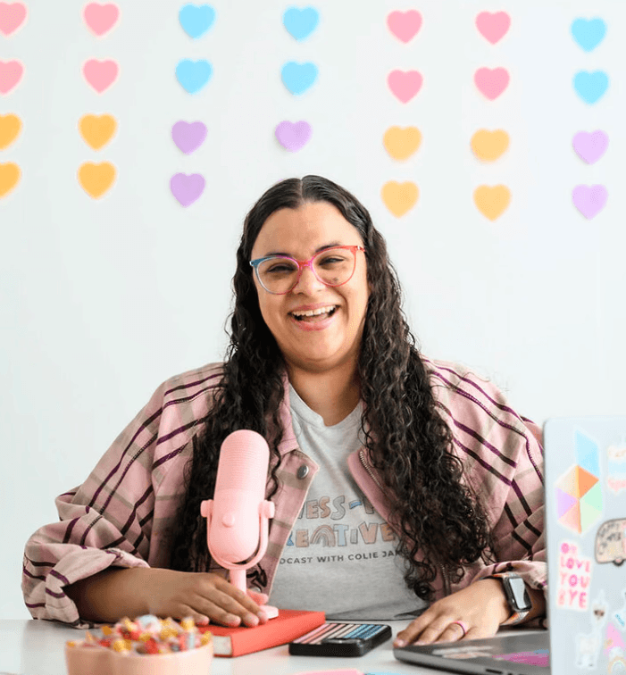 Creative founder speaking into a pink microphone in a colorful studio.