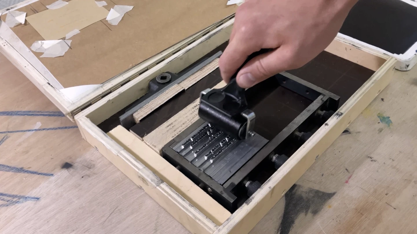 Encrage au rouleau d'une composition en caractères mobiles avant impression typographique artisanale