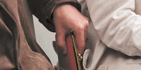 A man stealing a wallet out of someone's pocket