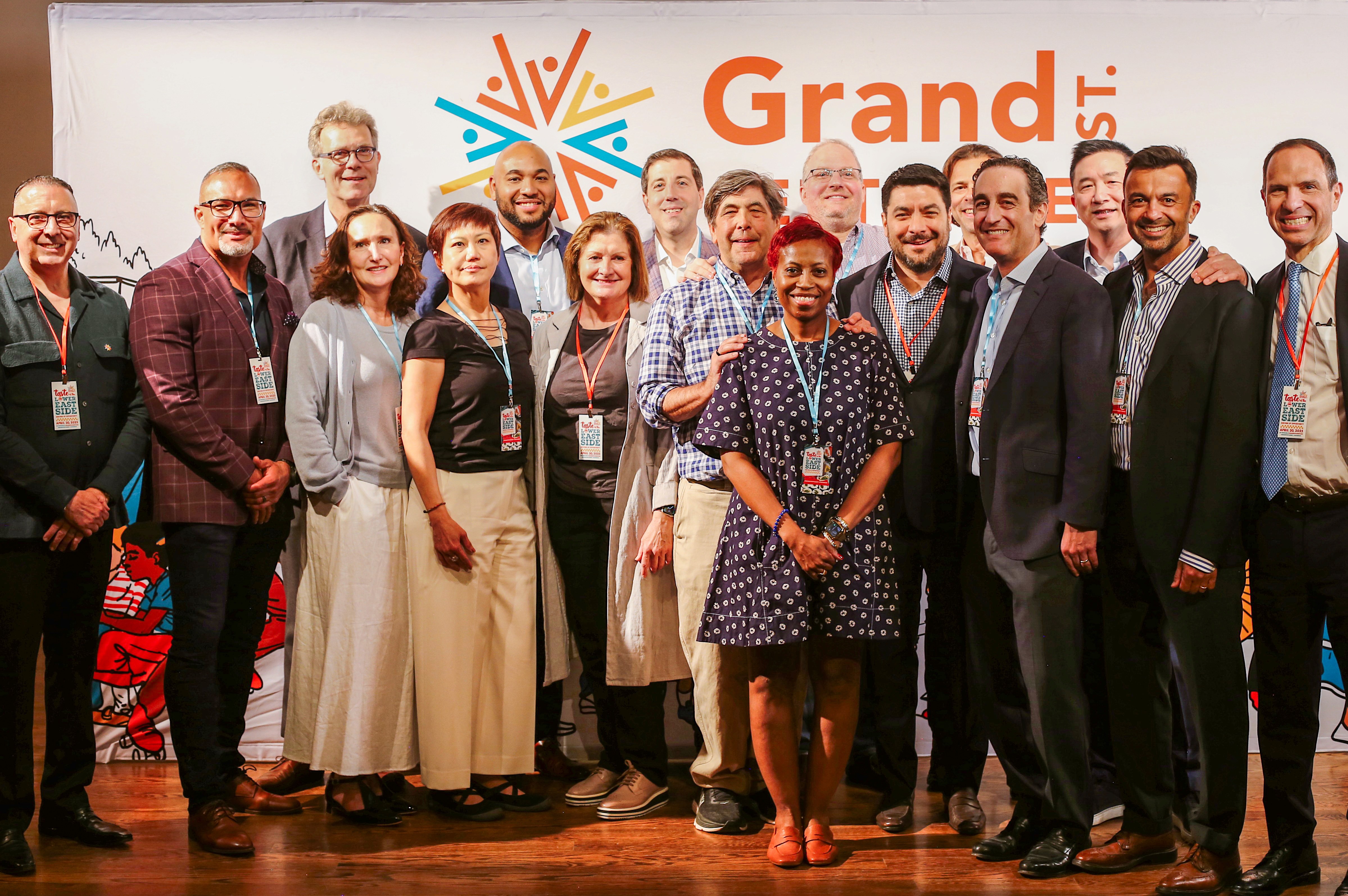 A picture of Grand St. Settlement's Board of Directors in front of an illustrated backdrop.