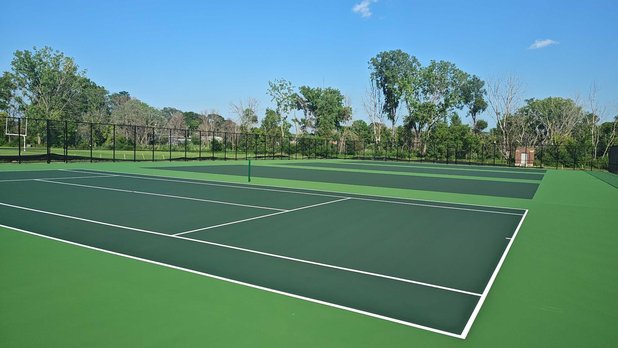 Freshly resurfaced tennis court with vibrant green finish