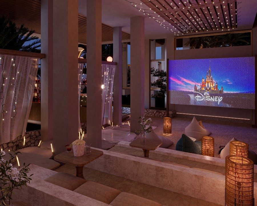 A movie theater interior featuring a large screen and illuminated lights