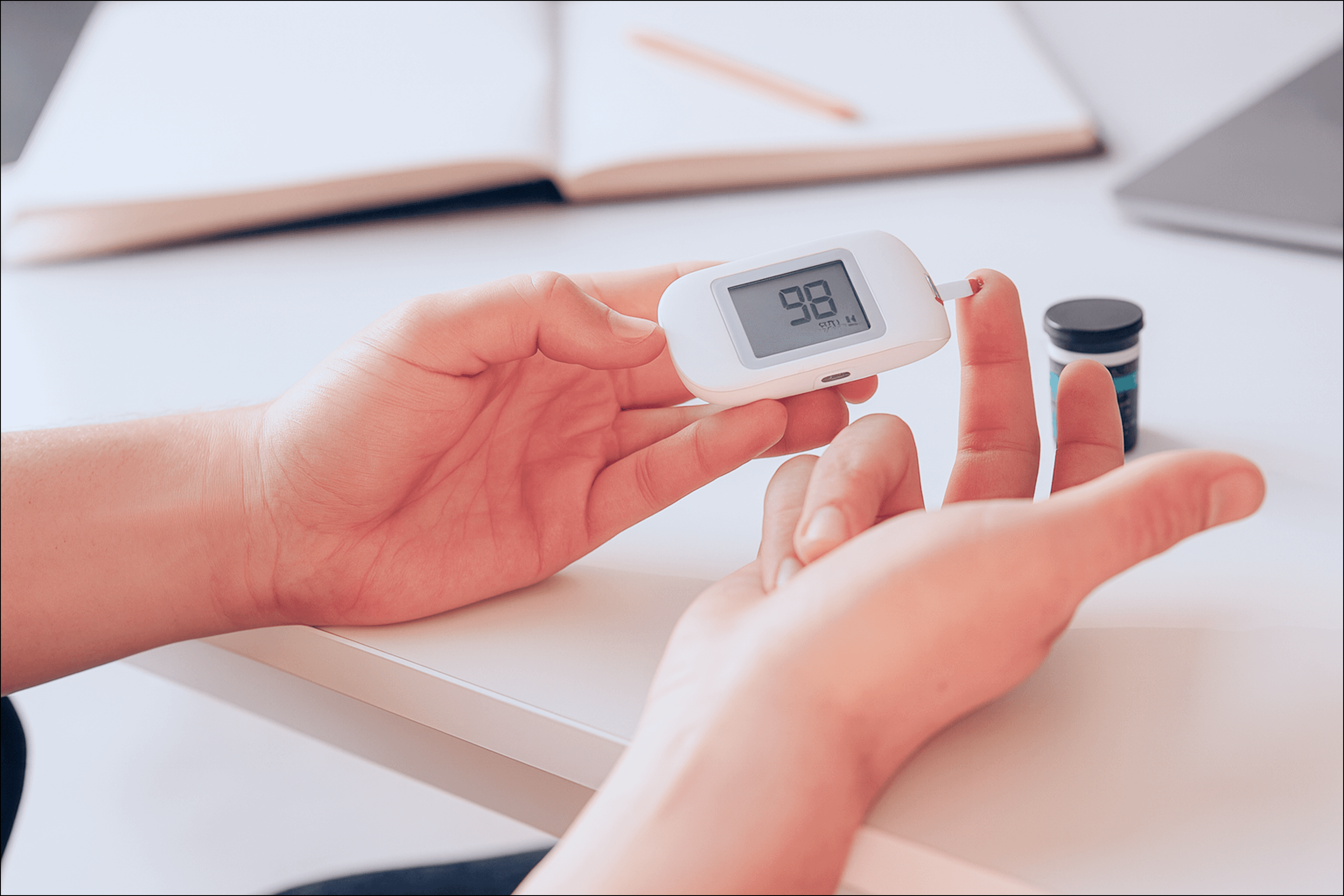 Person checking blood glucose with a handheld monitor, representing remote patient monitoring devices used to track vitals at home and share health data with care teams.