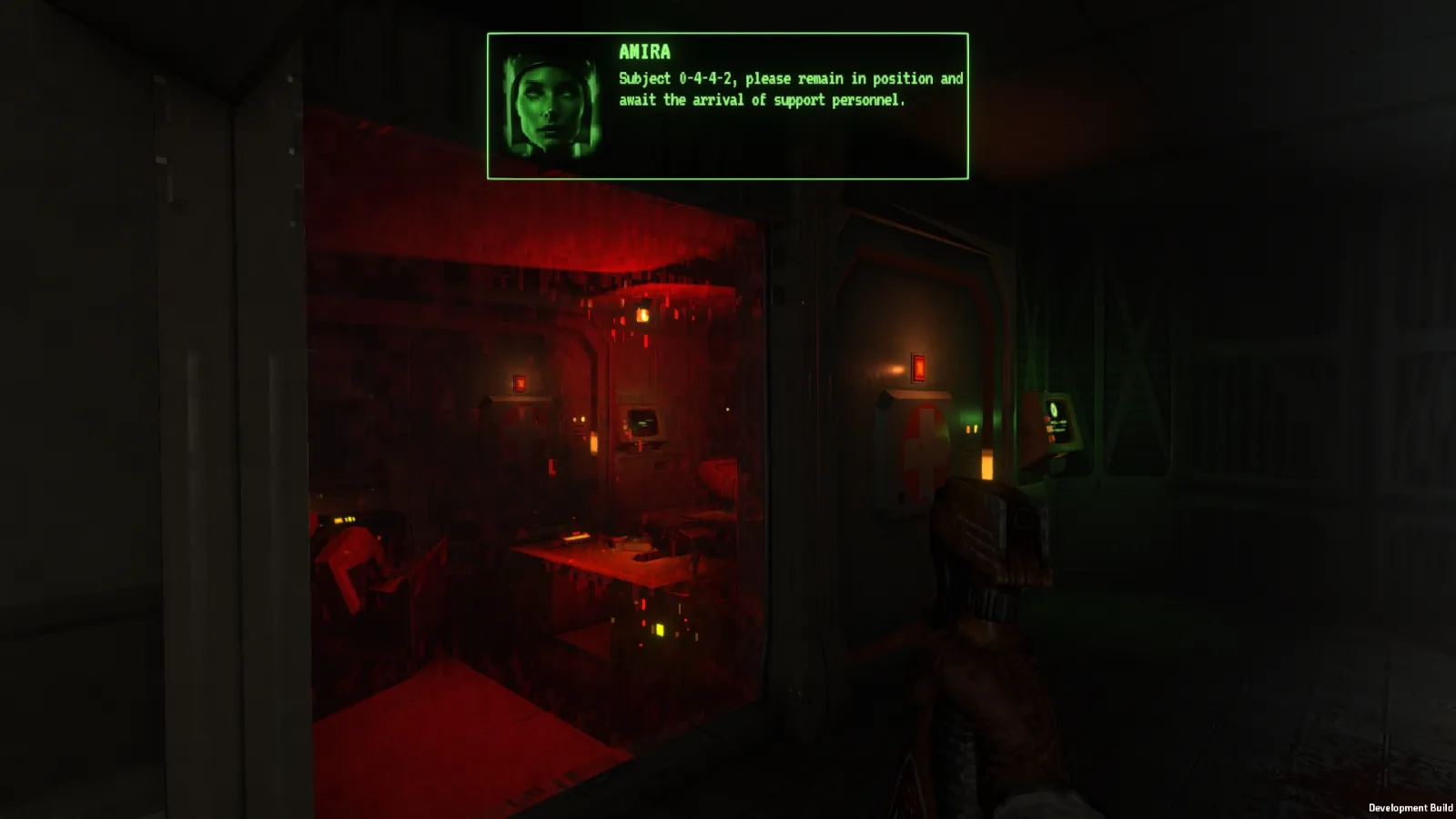 A dimly lit control room glows red from various computer screens, while a message on a green overlay reads, "Subject 9-4-4-3, please remain in position and await the arrival of support personnel," creating an ominous and tense atmosphere.