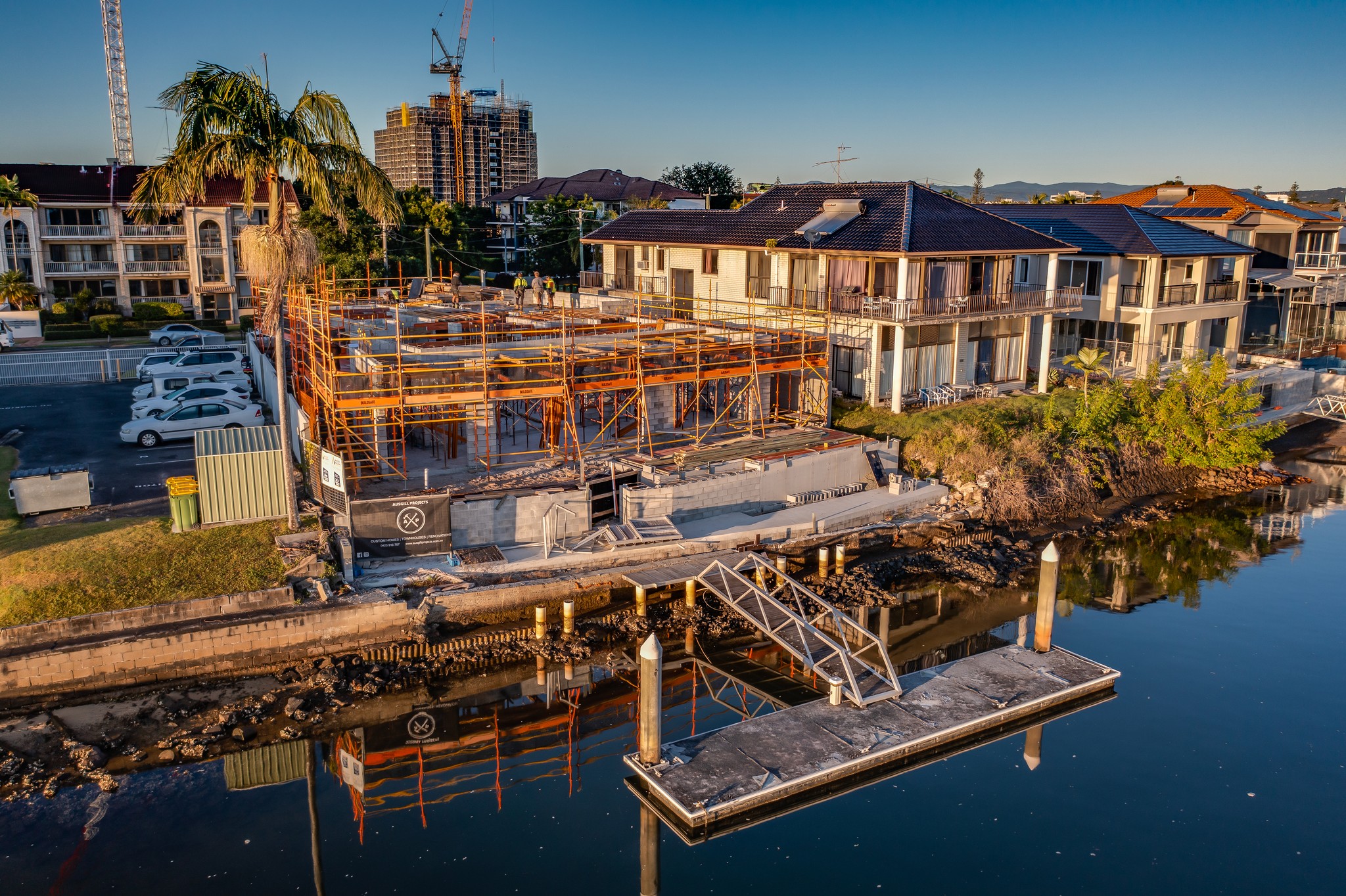 A winding road cuts through rocky terrain, surrounded by patches of green grass and illuminated by sunlight.
