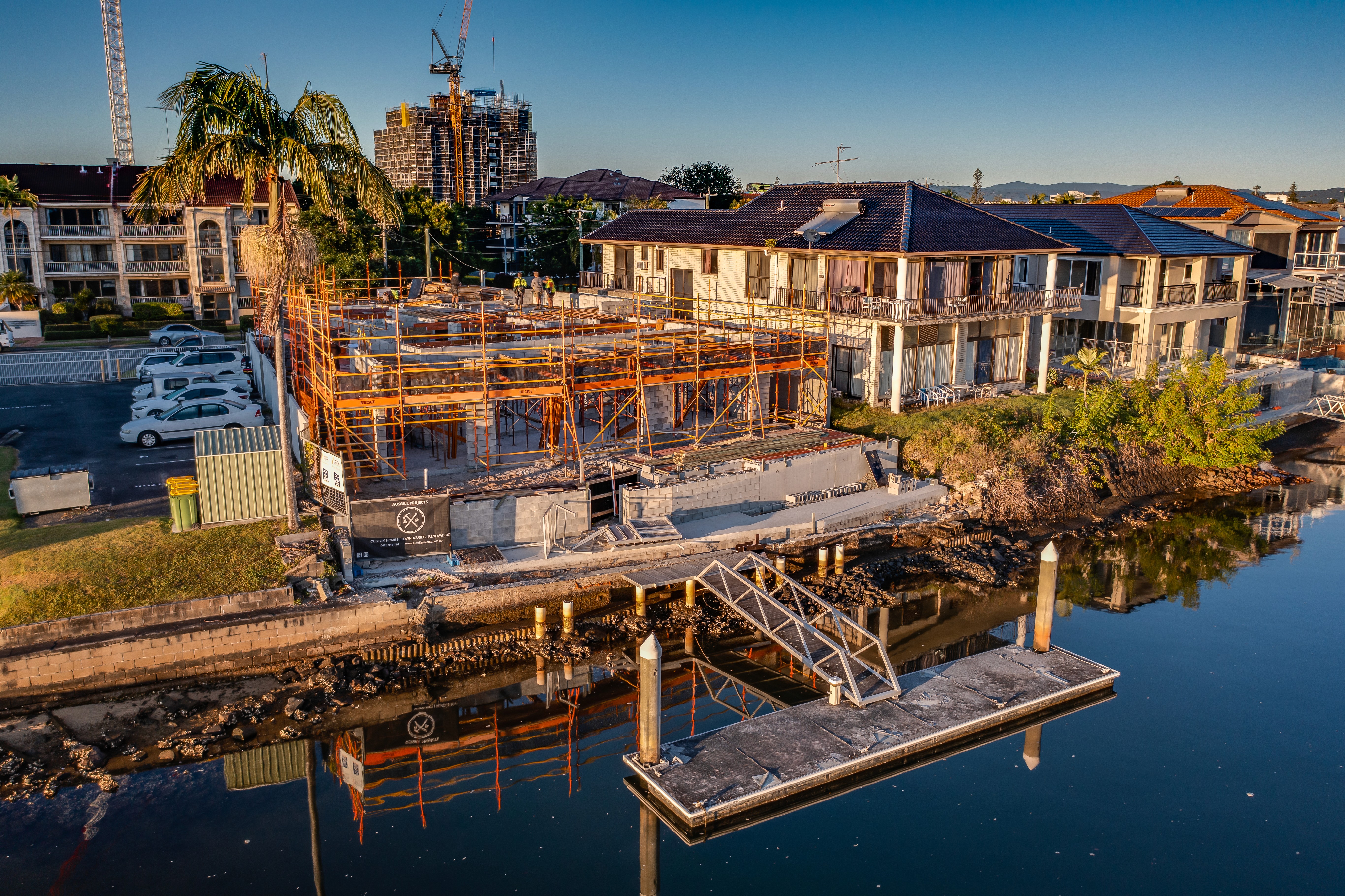 A winding road cuts through rocky terrain, surrounded by patches of green grass and illuminated by sunlight.
