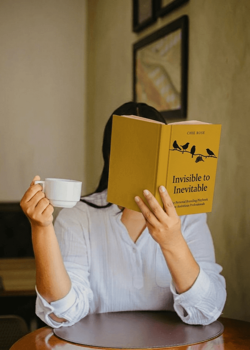 Woman reading a book while enjoying a cup of coffee in a cozy setting.