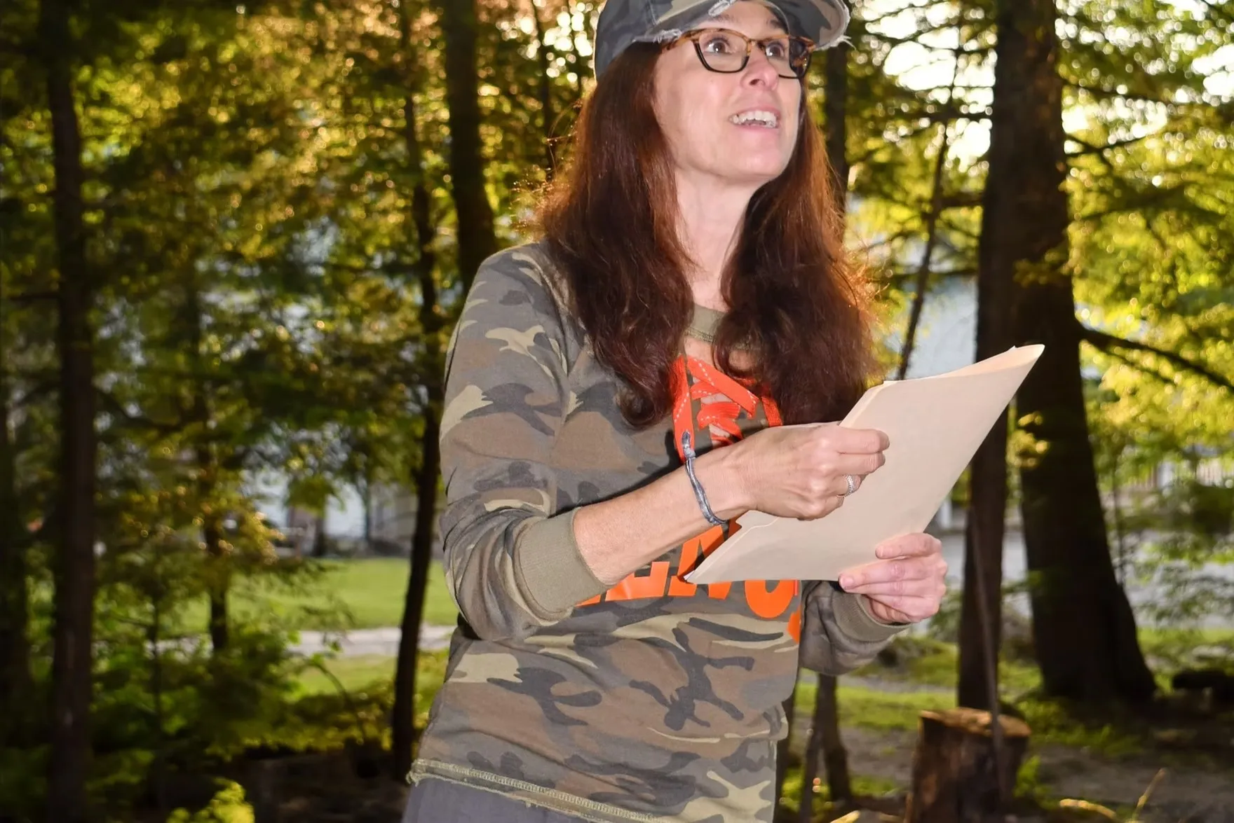 Stephanie Moss reading announcements to campers outdoors
