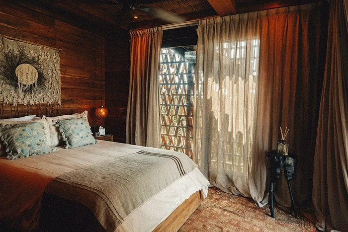 Experience the ultimate in luxury and relaxation with the treehouse suite at Nomade Holbox in Holbox Mexico, featuring a comfortable bed and modern amenities