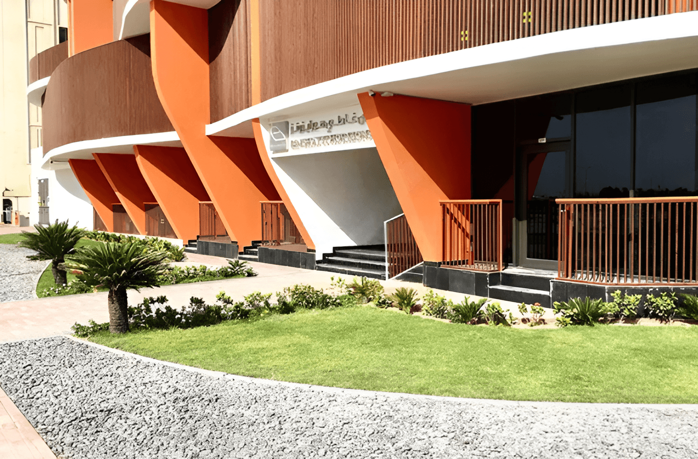 Binghatti Horizons features a tall, curved facade, located alongside a busy road.