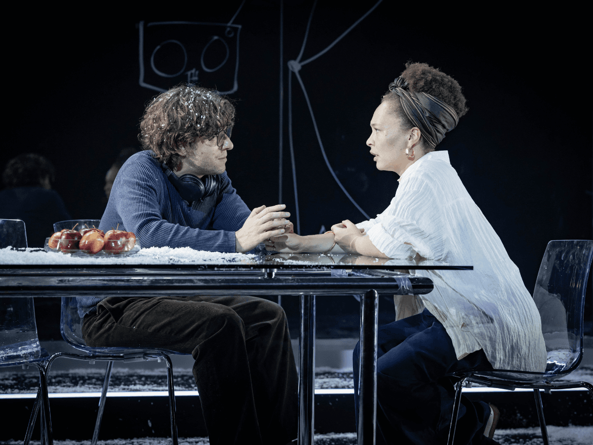 Two people holding hands across a table in an intimate scene from The Wanderers.