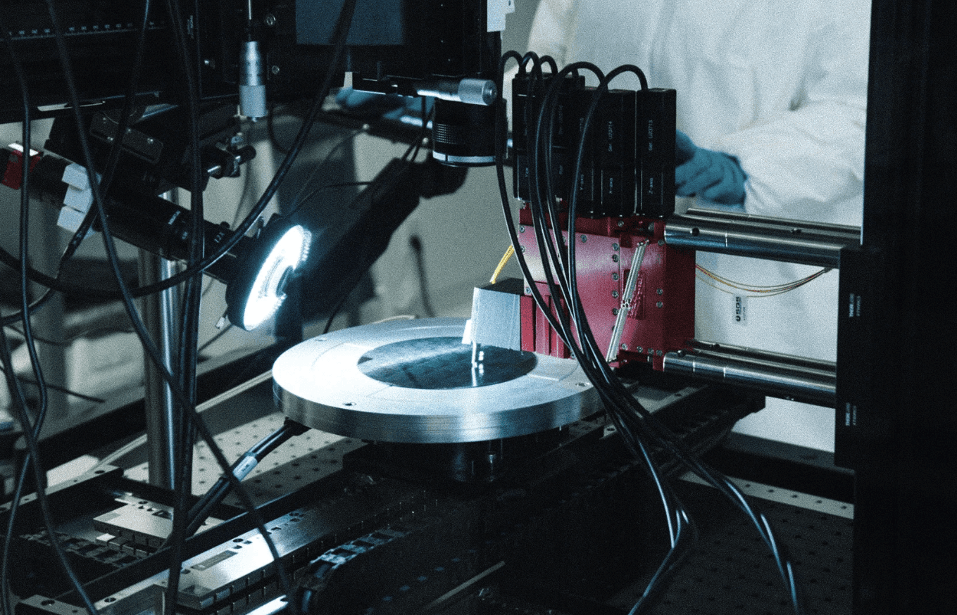 Precision manufacturing tools for semiconductor marketing, with a robotic fixture and red laser glow in a high-tech lab.
