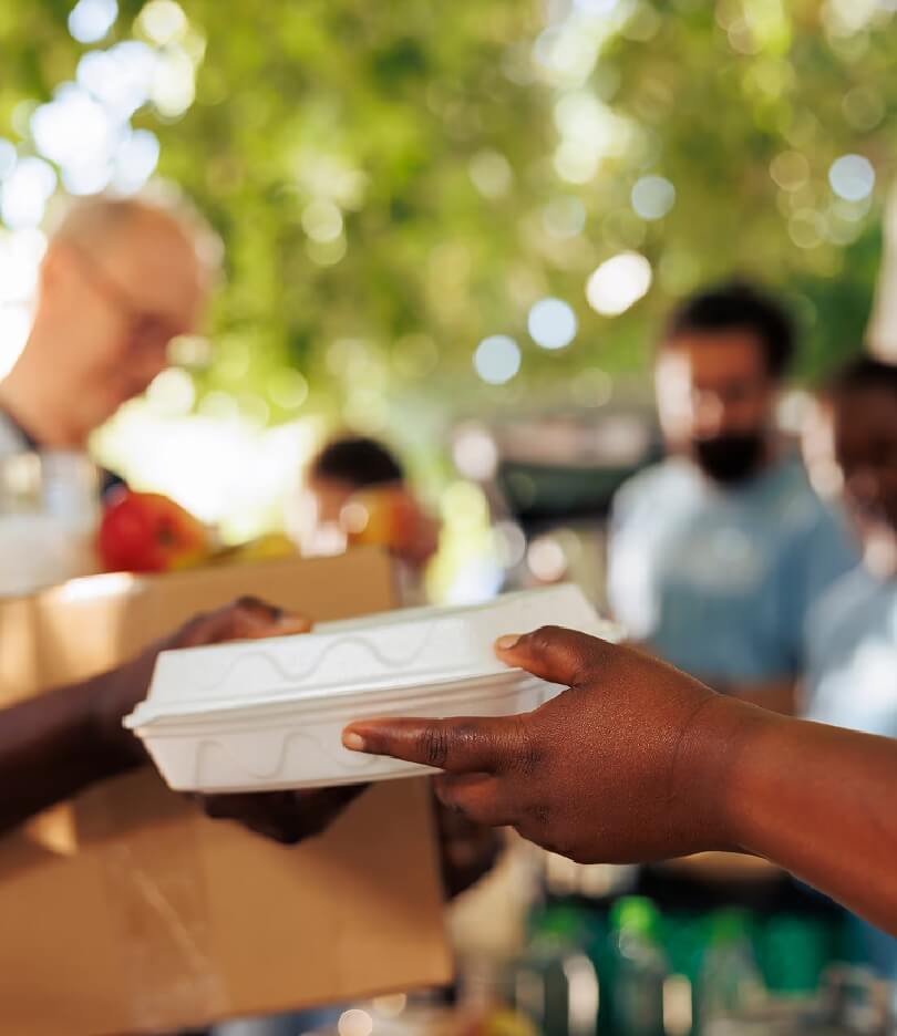Workers handling packages in a warehouse with industrial equipment in the background.