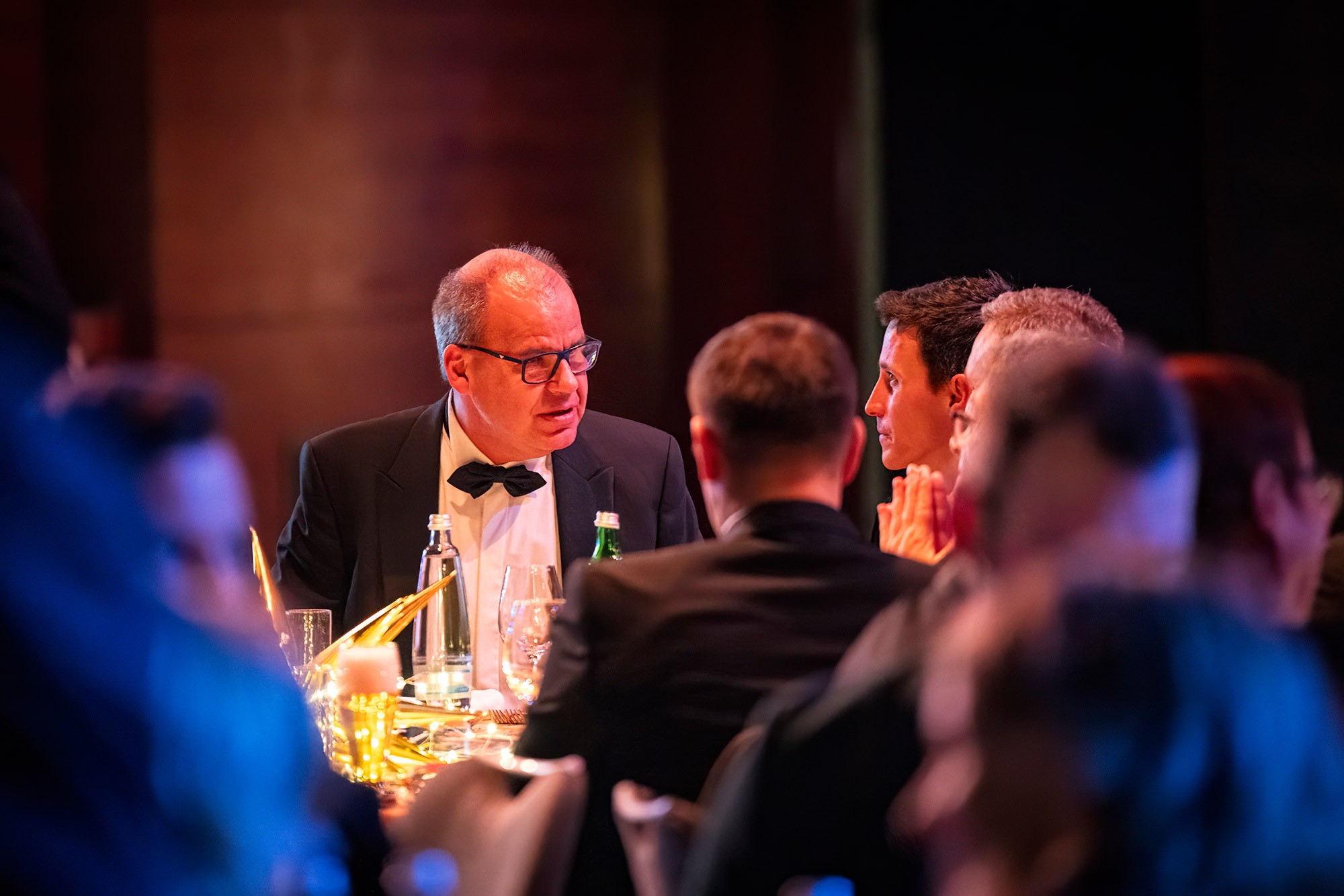 Executives in formal attire networking during the gala dinner at the CWS Workwear international sales conference in Prague.
