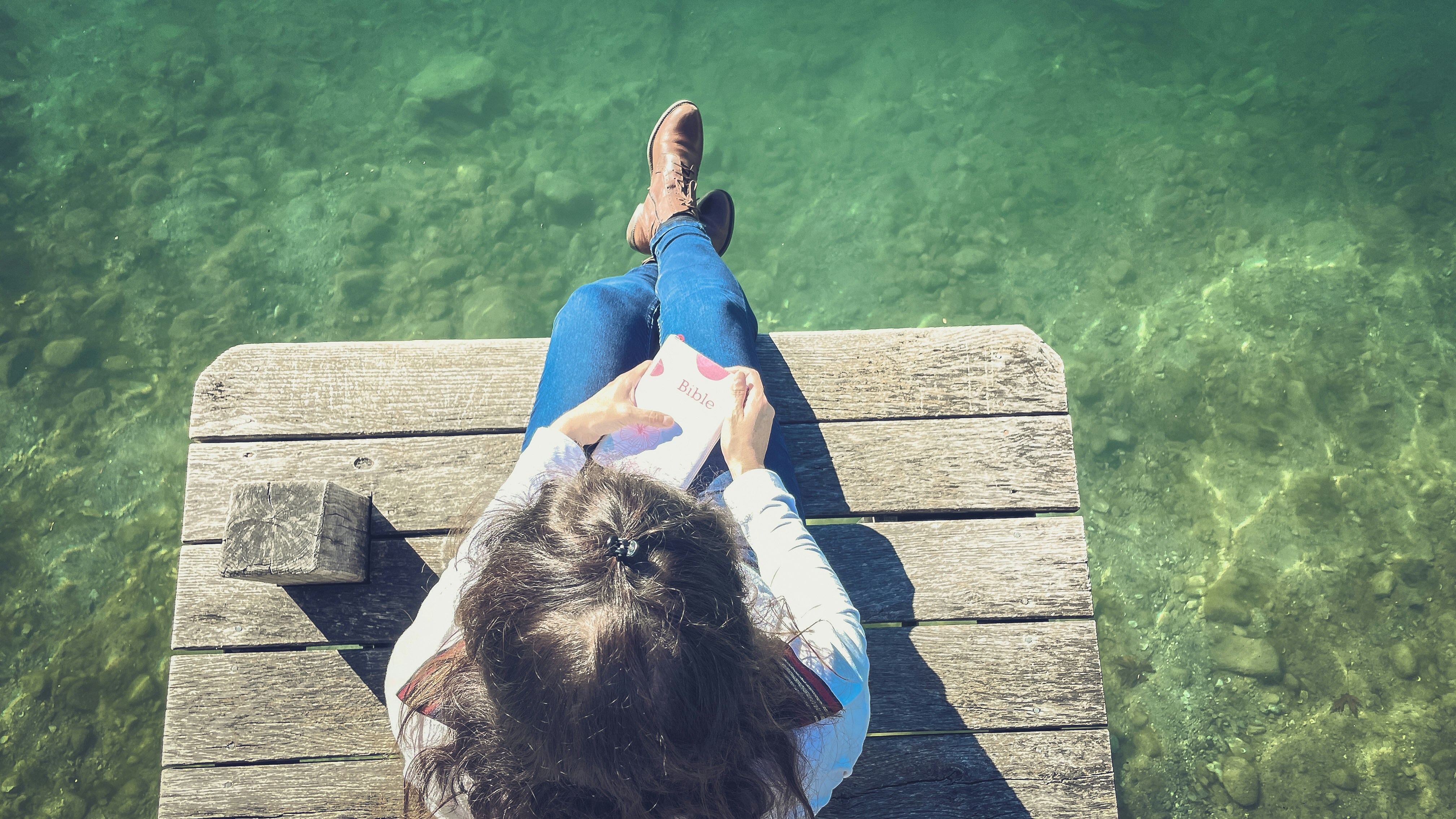 a person sitting on a bench reading a book