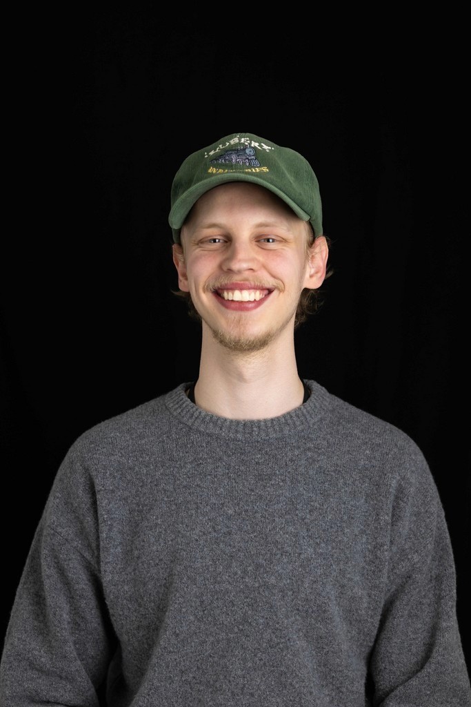 Portrait of a laughing person with curly hair wearing a white shirt