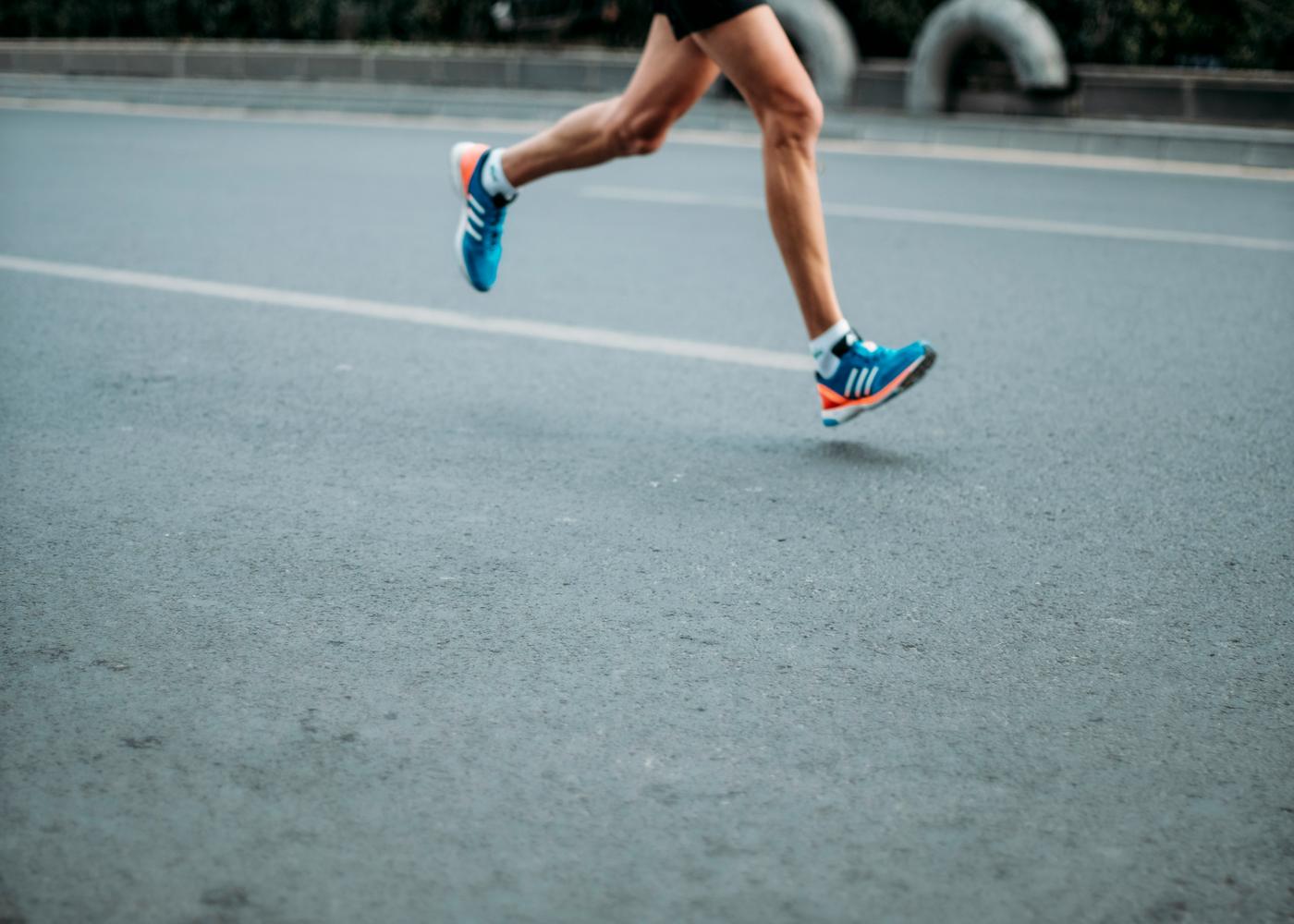 Man running while wearing Adidas marathon runner shoes
