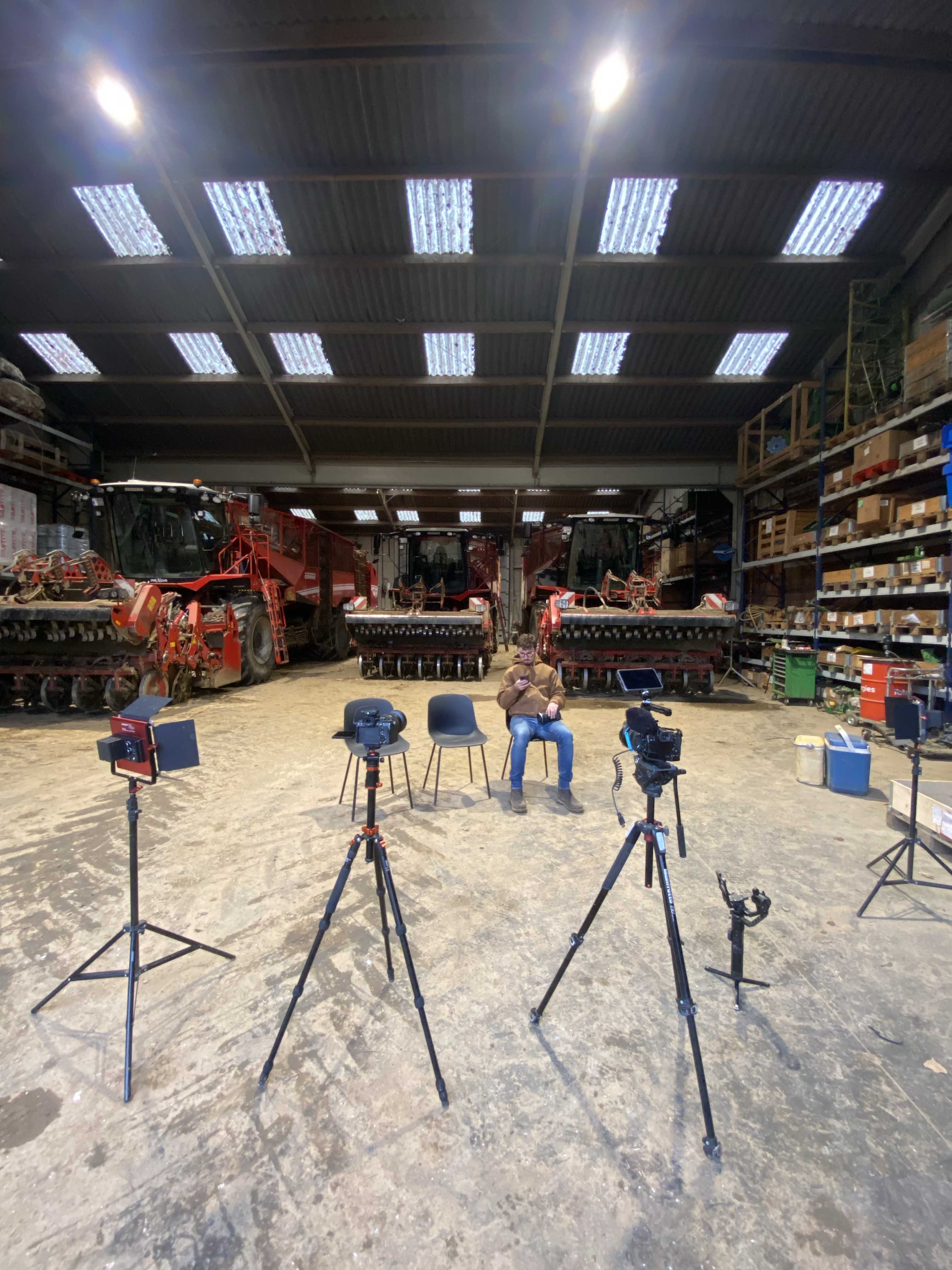 Black and white image of people working at a table with laptops, showing hands gesturing during discussion of digital content displayed on screens, with fabrica® logo in the corner.