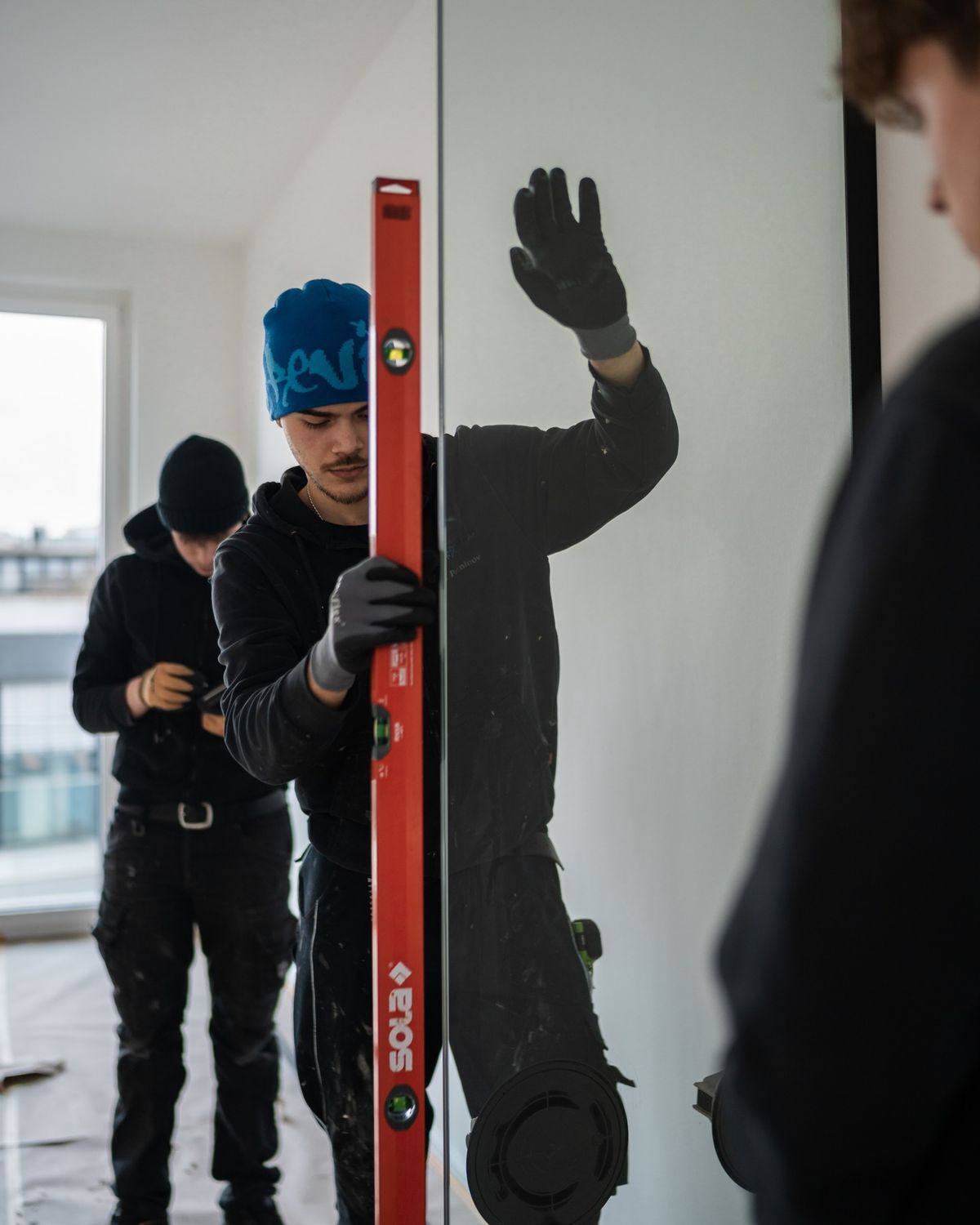 Close-up of a dark green leaf showing its textured surface and central vein against a muted background.