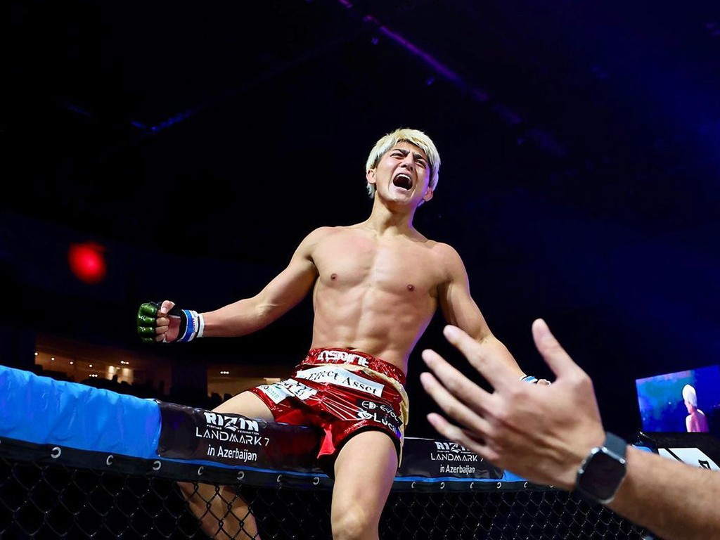 A close-up of a pink cocktail in a martini glass, set against a nighttime background with soft, blurred colors.