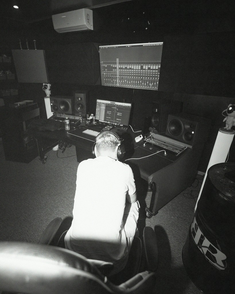 A black and white photo of a man in a recording studio
