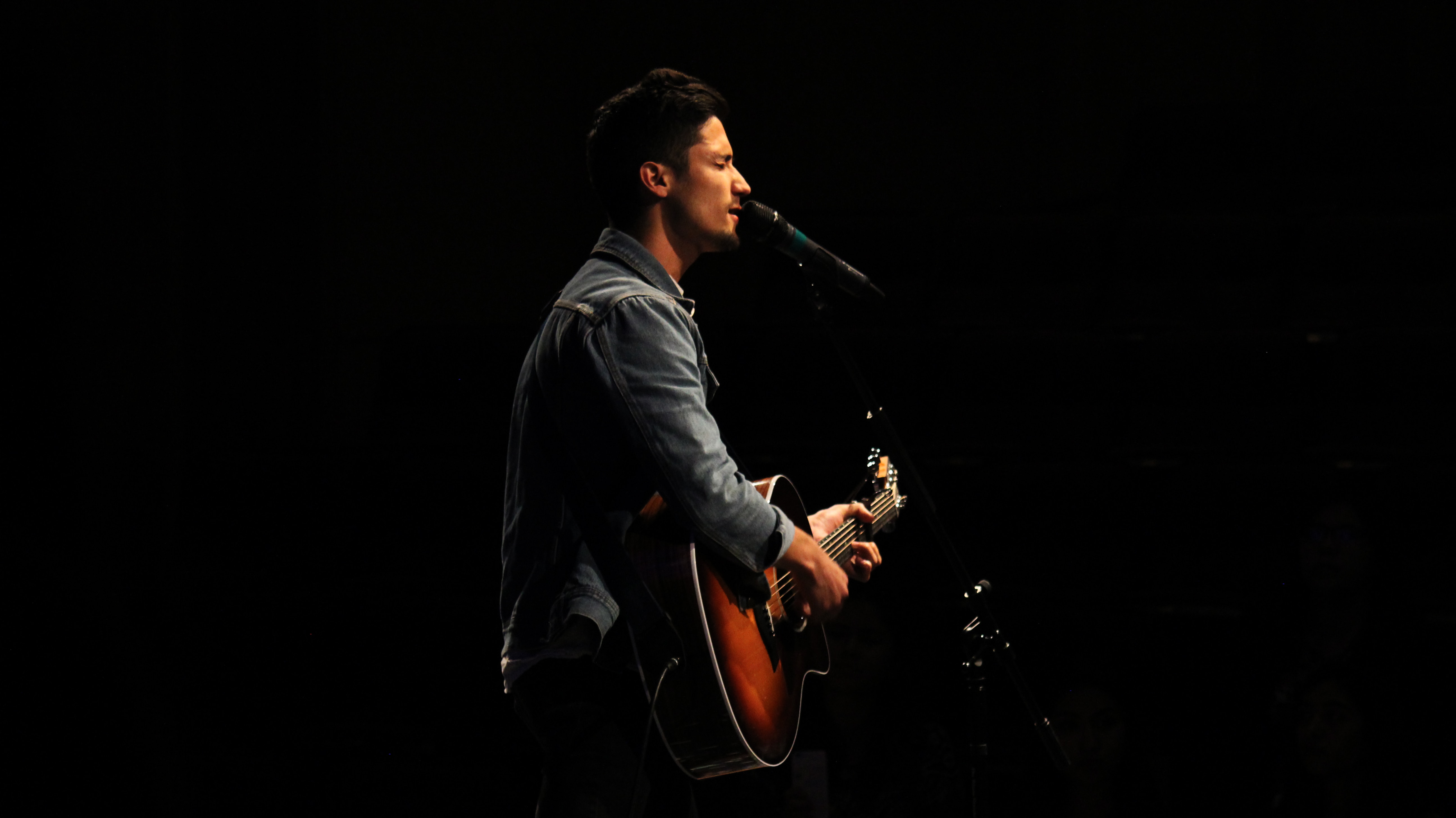 man with guitar singing on stage - ai singer software