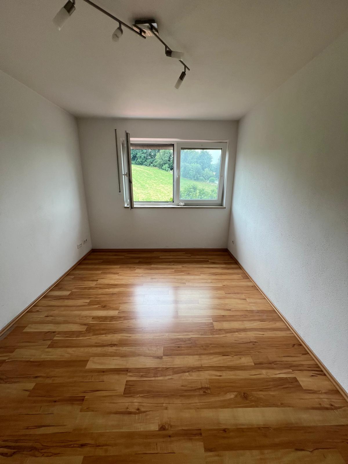 Entrümpelung Freising ein Mann ist an der Wand angelehnt und Grinst in die Kamere, Es scheint so als ob der Keller Entrümpelt wurde.