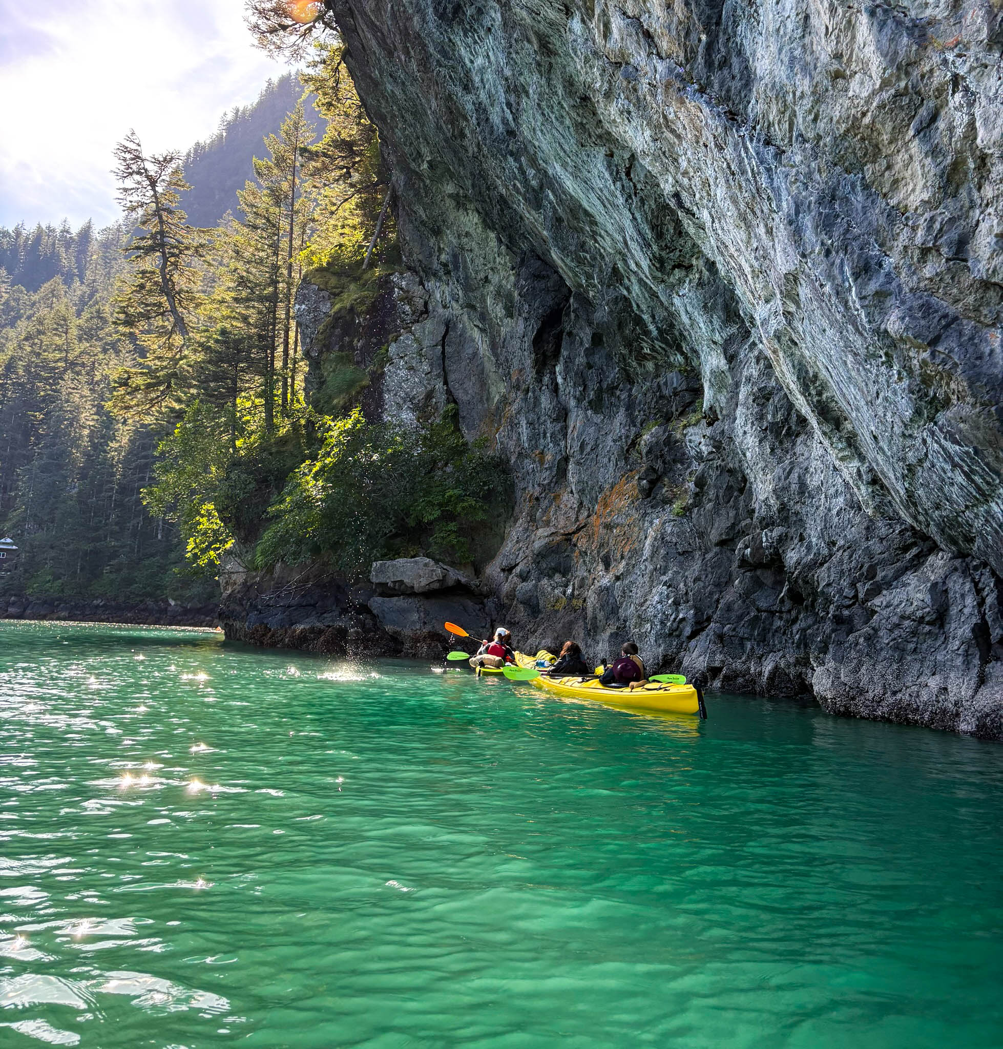 Three people in a yellow kayak