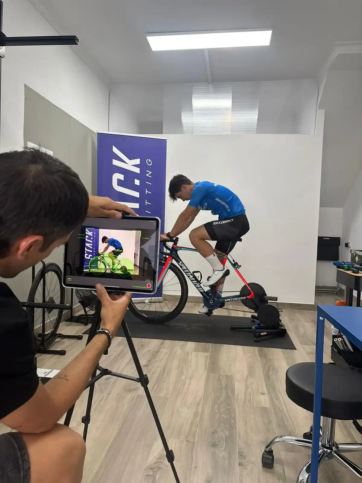 Cliente pedaleando en Stack Bikefitting y Carles analizándolo