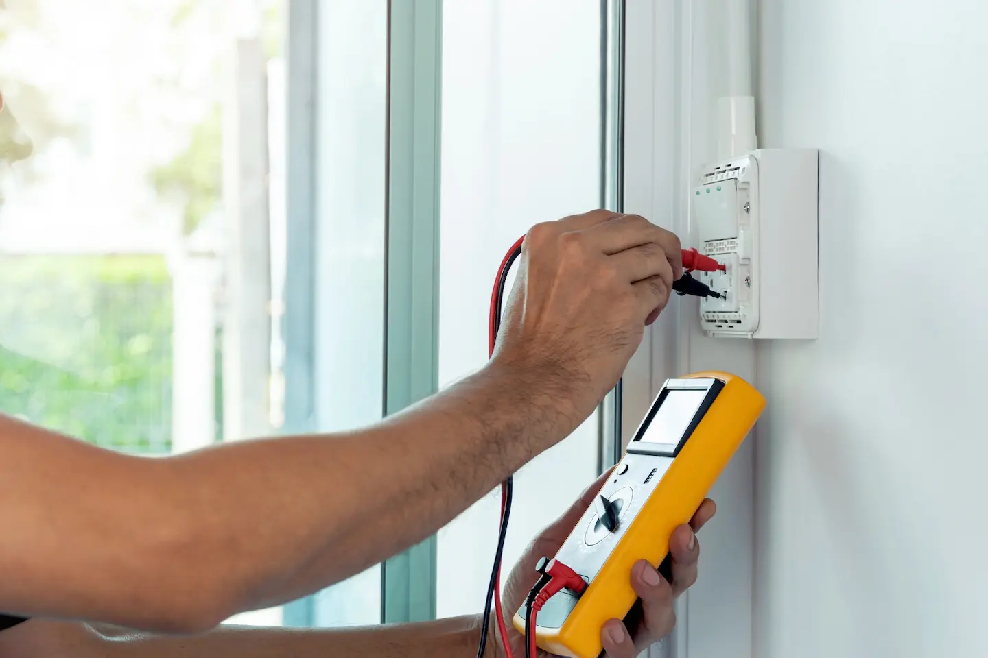 Technicien contrôlant une installation électrique avec un appareil de mesure