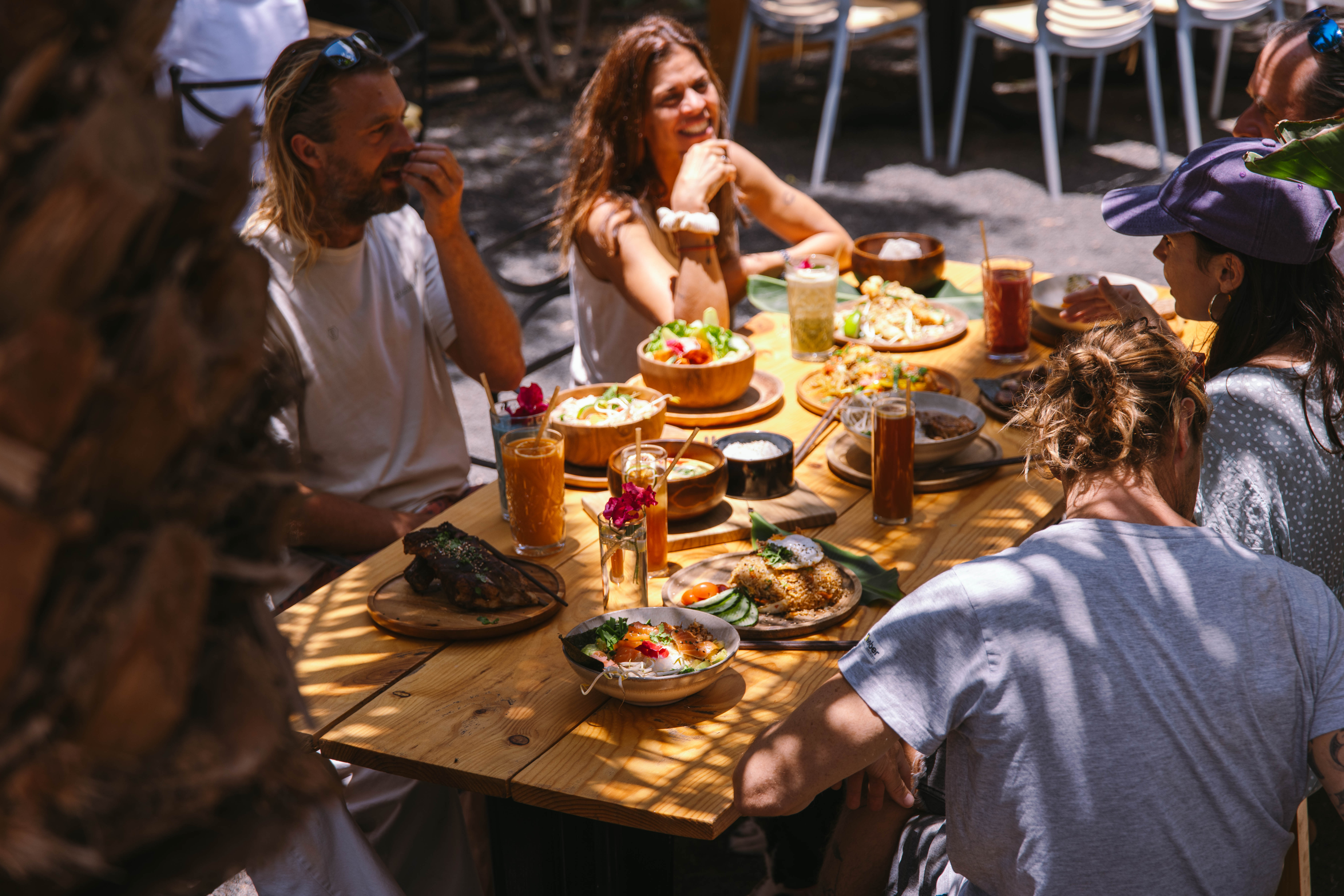 Five people gather at an outdoor cafe table.