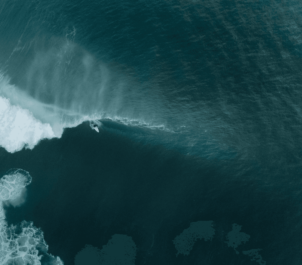 A birds eye view of a surfer riding a wave