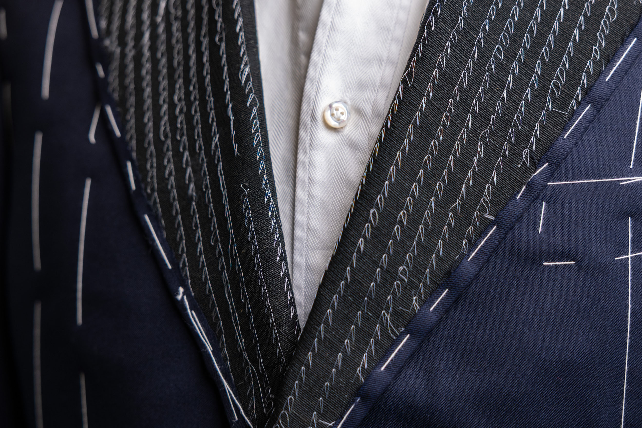 A close-up of a Don Marrón bespoke jacket during its hand-stitched construction, showcasing intricate canvas work, fine detailing, and the artistry of luxury tailoring.