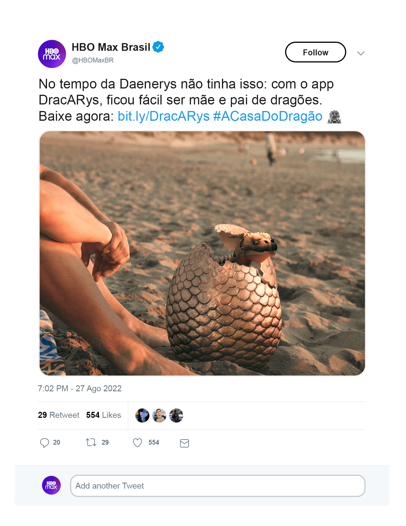 Man on a beach with a dragon’s egg hatching in the sand beside his feet in a social media promotion.