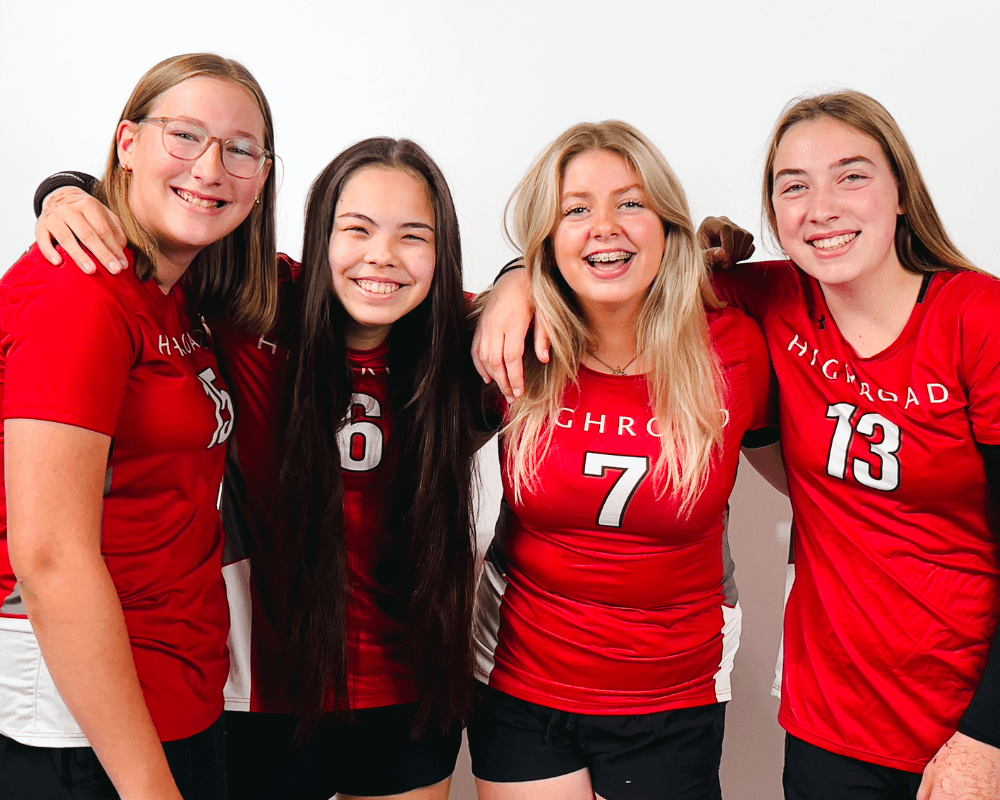 A multi-generational family poses for a group portrait outdoors.