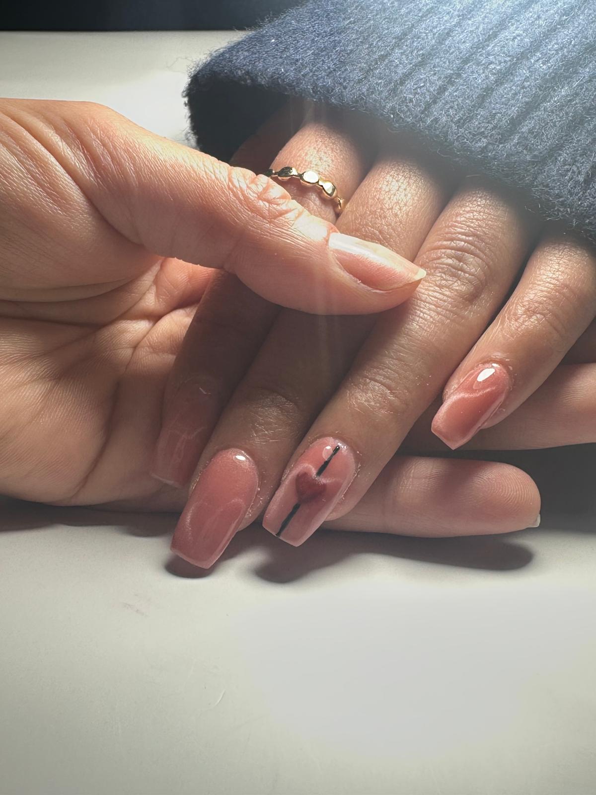 Hand with light pink nails and rings on cozy blanket