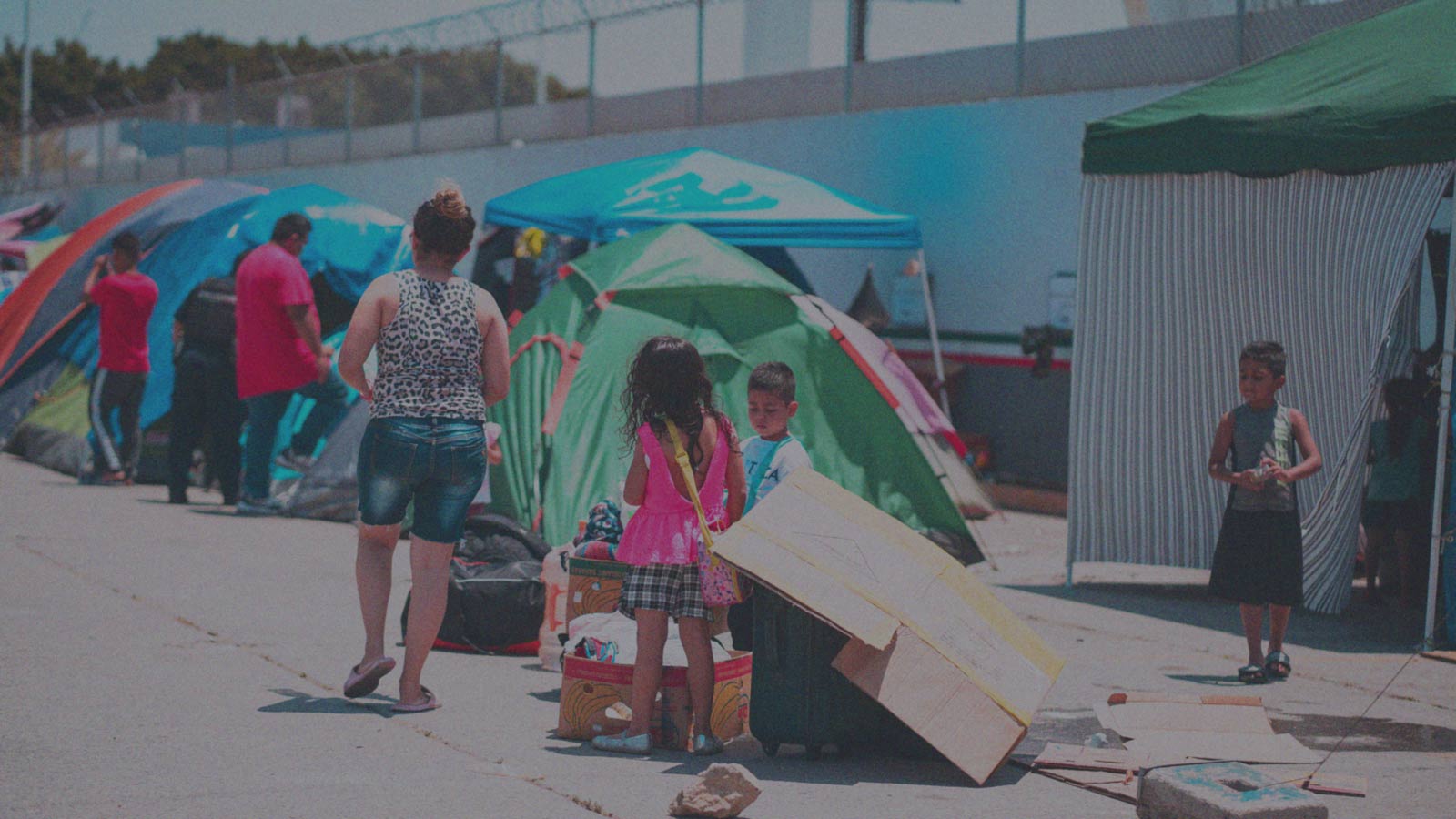 Foto que muestra a personas migrantes en carpas, en la columna "Medidas migratorias: ni eficientes ni dignas" de IdeaPaís.
