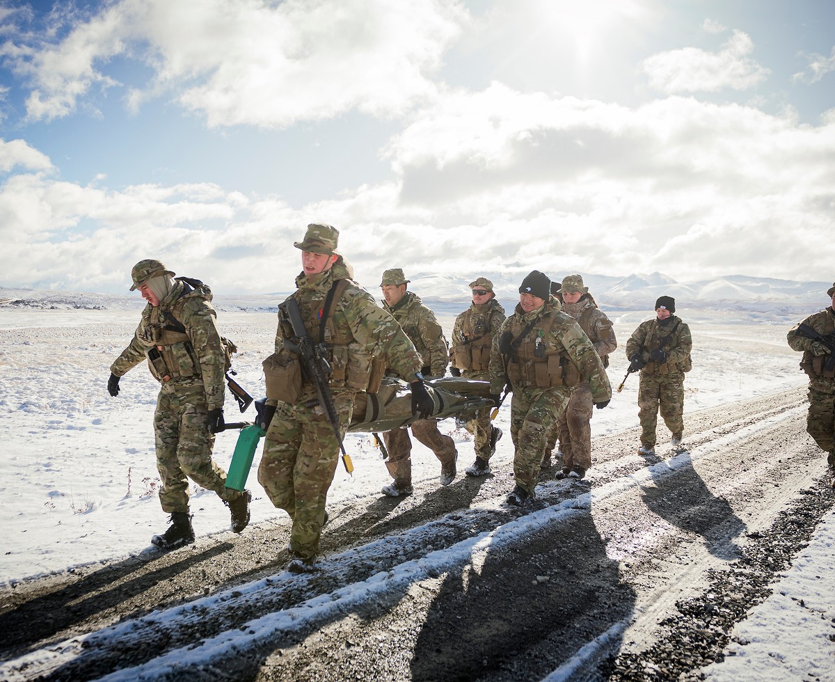 Image of a team of soliders working together to carry somone