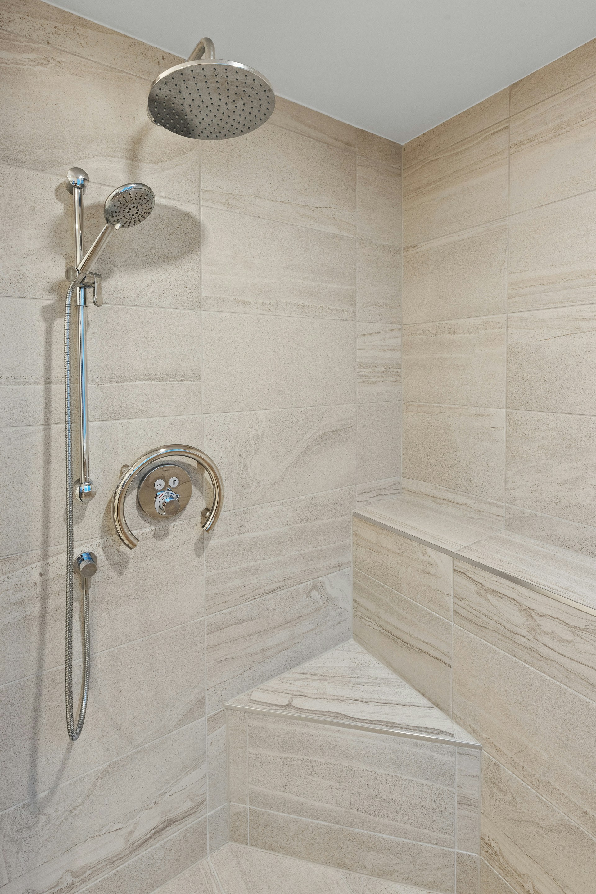 An elegant shower design with a traditional shower head and a detachable handheld shower head for flexible use.